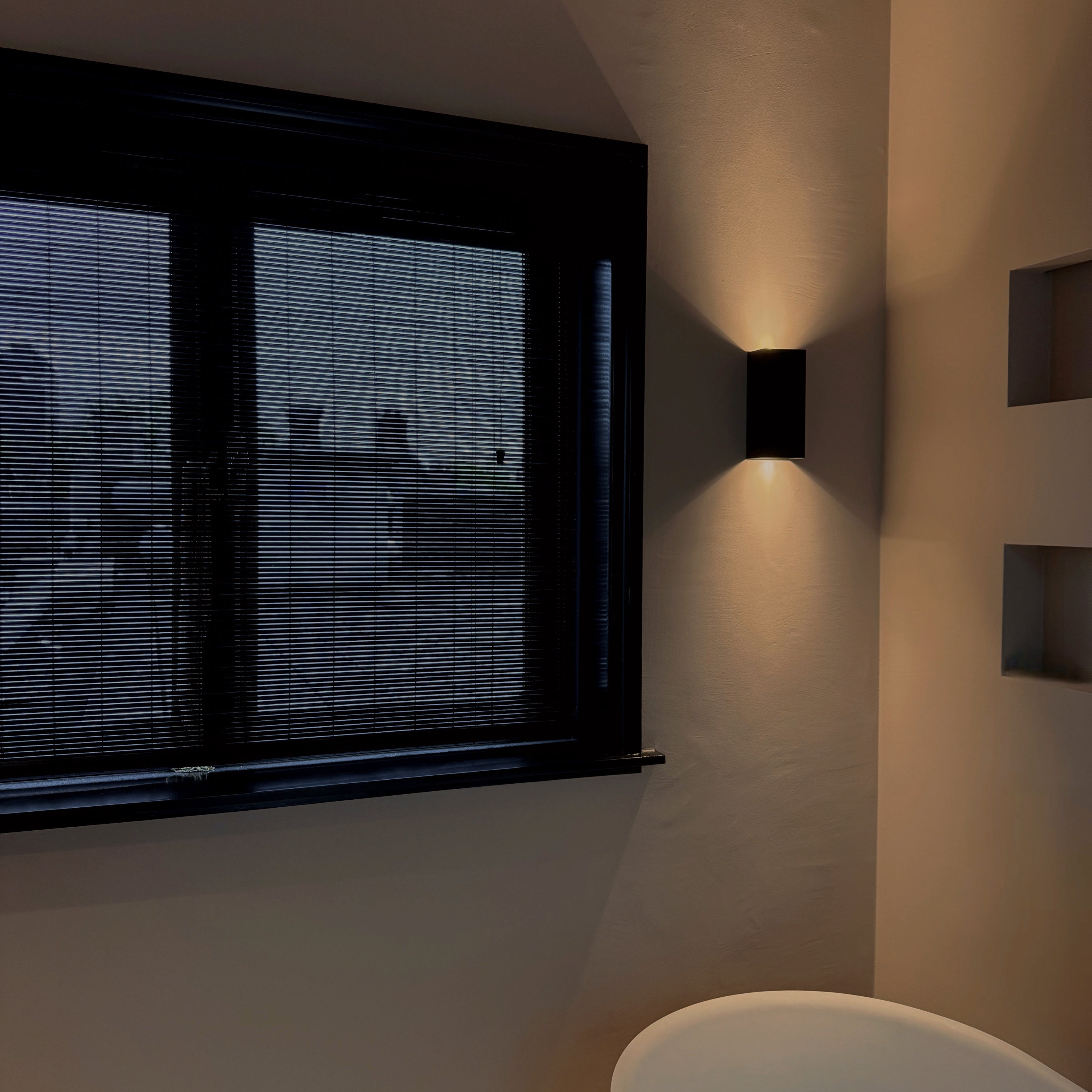 Moderne badkamer met Zwarte bamboo voor privacy en indirect licht tegen de muur.