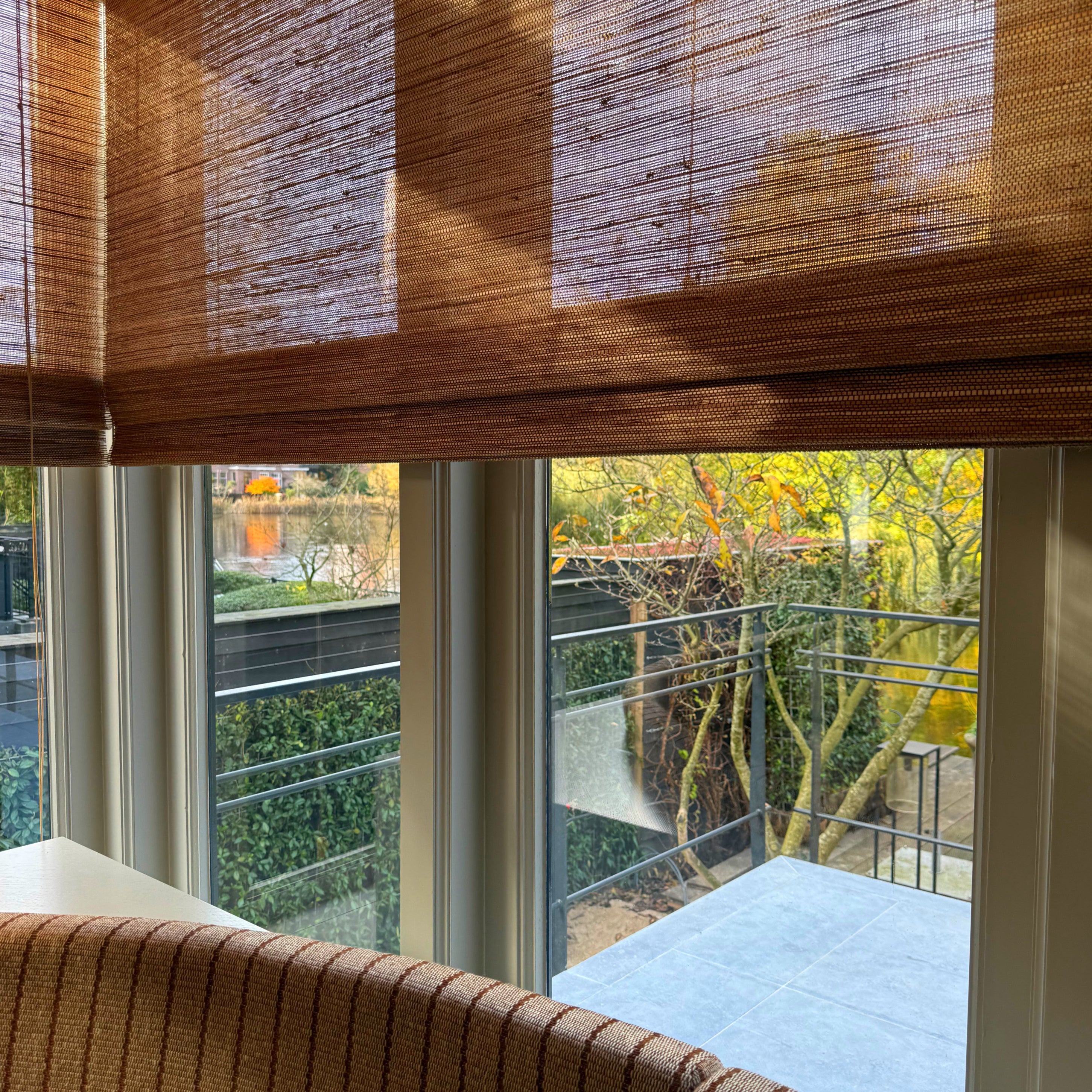 Hoekraam met vouwblind die zonlicht in zachte patronen filteren.