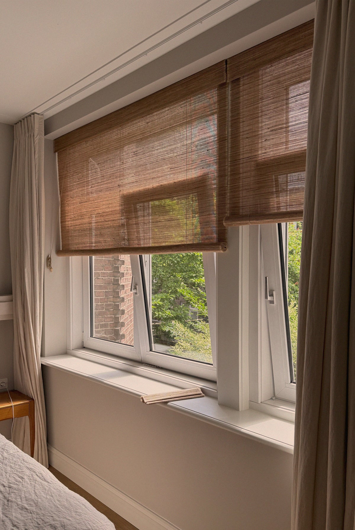 rolgordijnen en gevoerde linnen gordijnen in combinatie in een slaapkamer