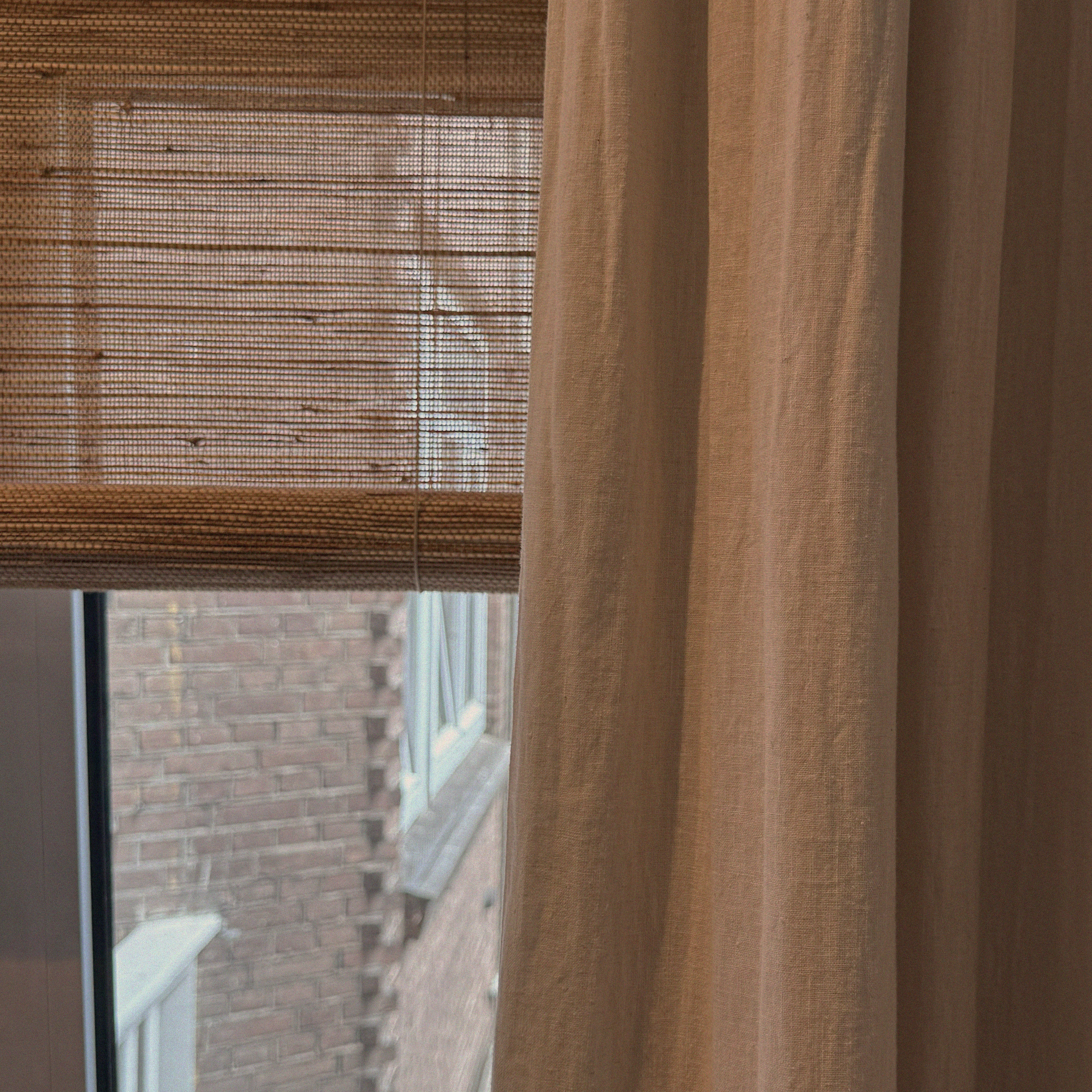 rolgordijnen en gevoerde linnen gordijnen in combinatie in een slaapkamer