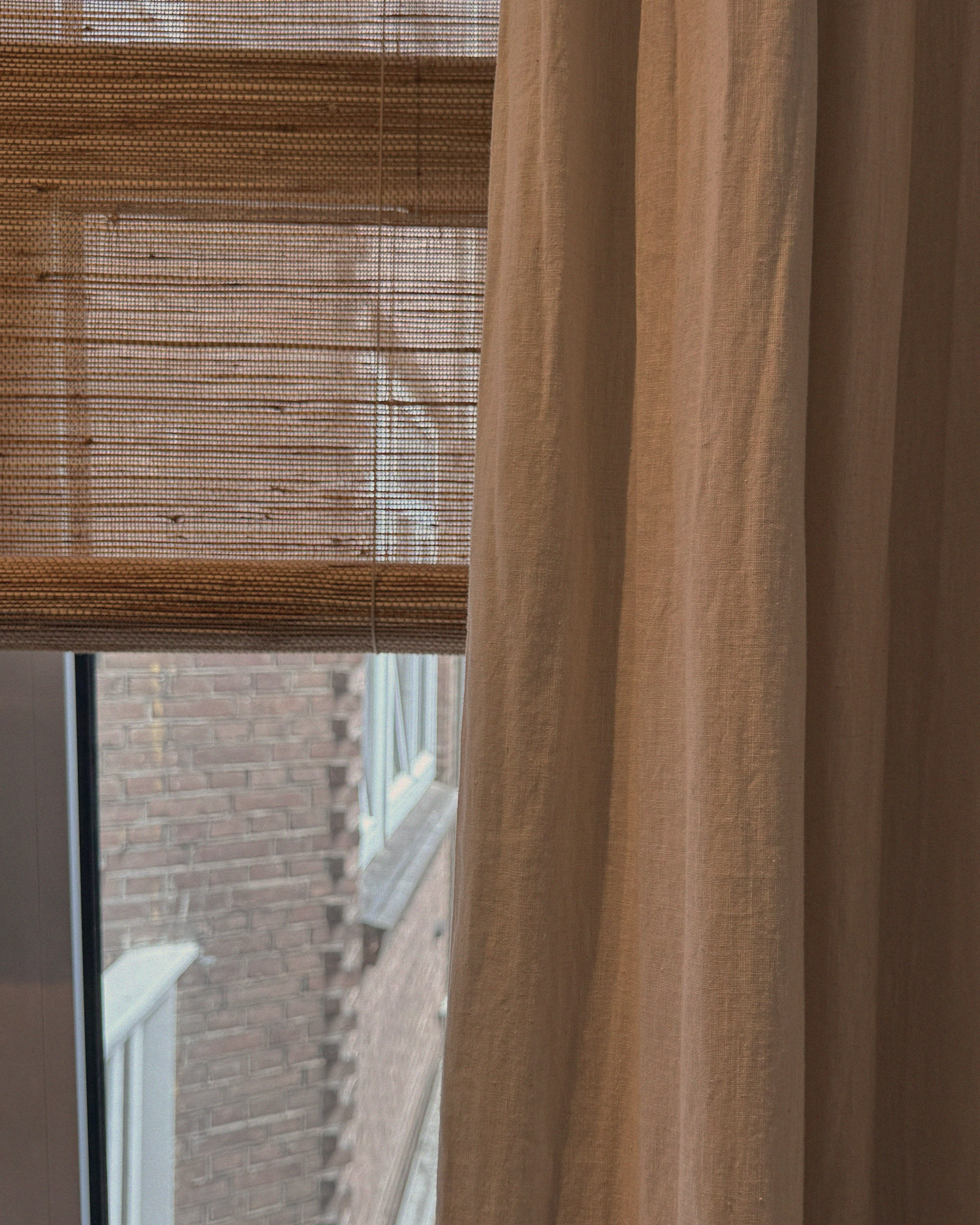 rolgordijnen en gevoerde linnen gordijnen in combinatie in een slaapkamer