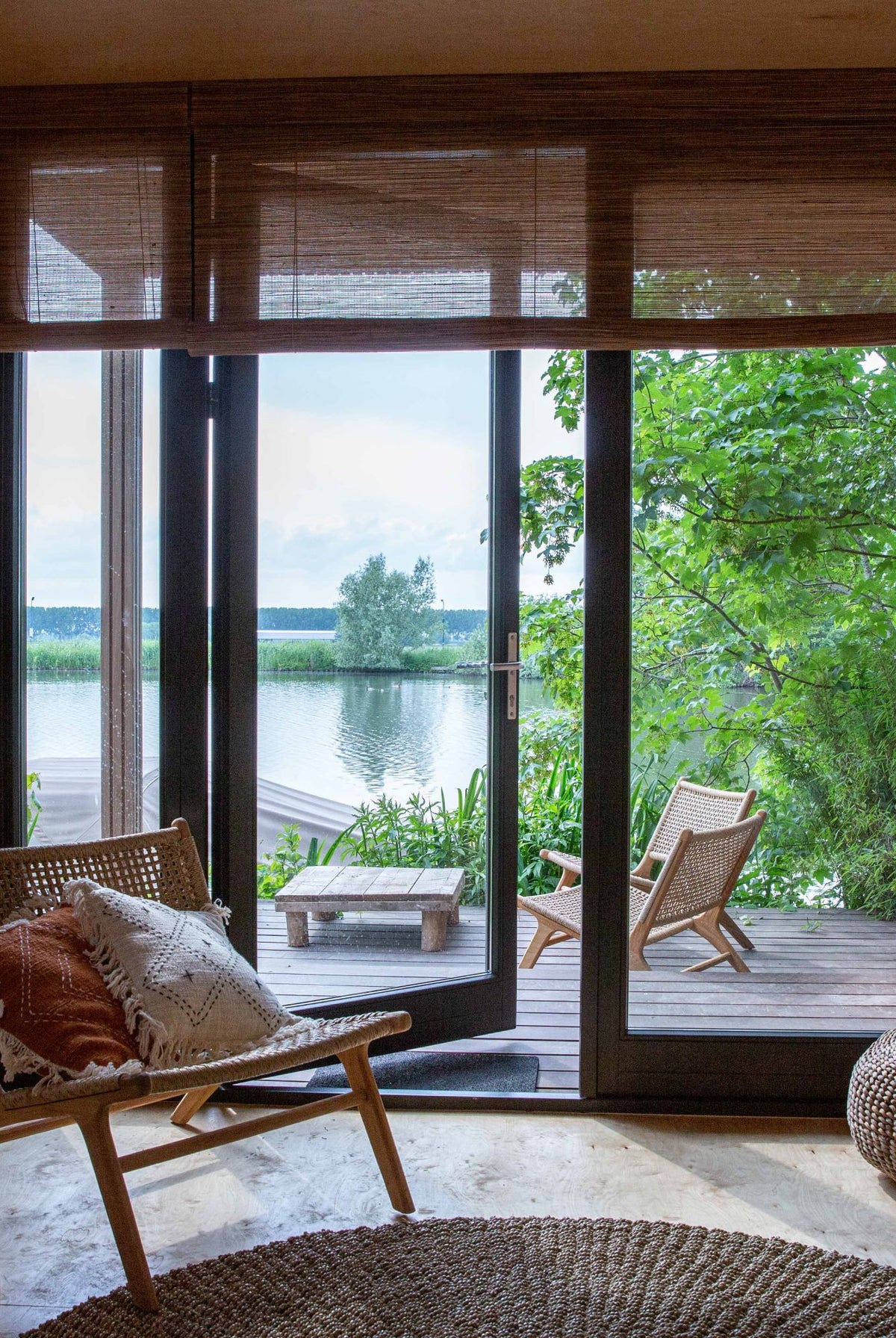 Tuamoto blinds in woonboot met warm gefilterd daglicht en uitzicht op het water.