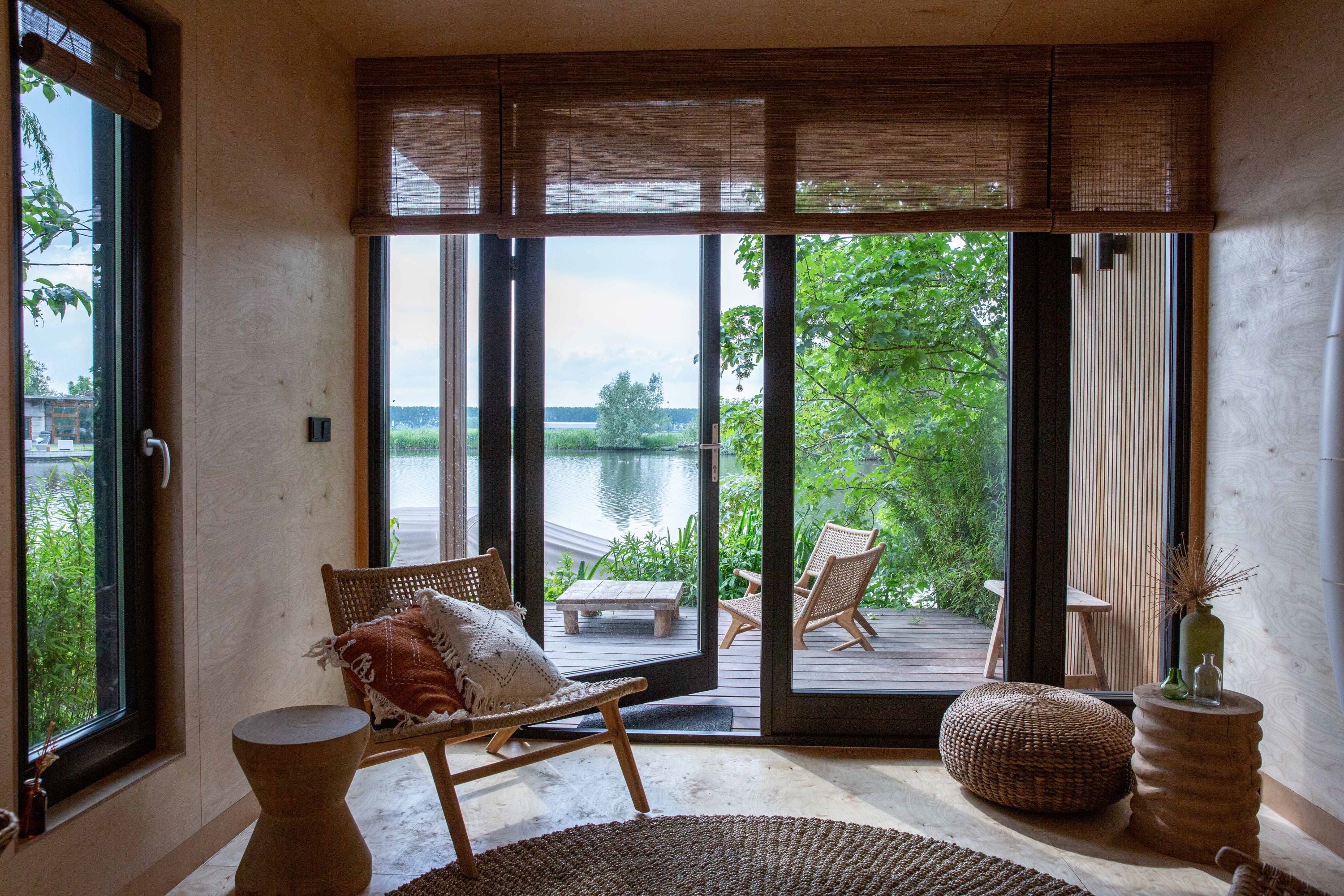 Tuamoto blinds in woonboot met warm gefilterd daglicht en uitzicht op het water.