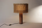 Elegante geweven lamp met terracotta betonvoet, straalt ambachtelijke warmte uit.