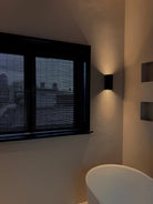 Moderne badkamer met Zwarte bamboo voor privacy en indirect licht tegen de muur.