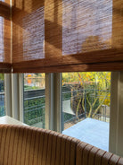 Hoekraam met vouwblind die zonlicht in zachte patronen filteren.