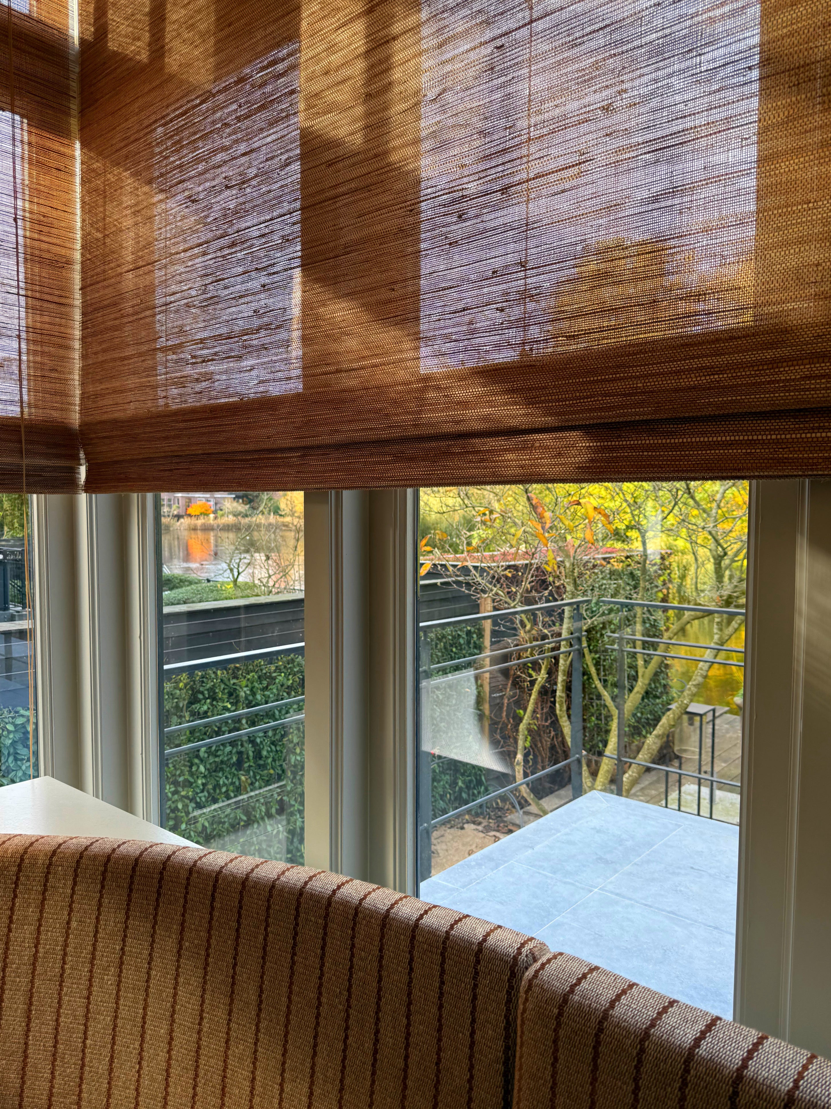 Hoekraam met vouwblind die zonlicht in zachte patronen filteren.