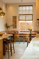 rolgordijn met schemerlamp en rode bank