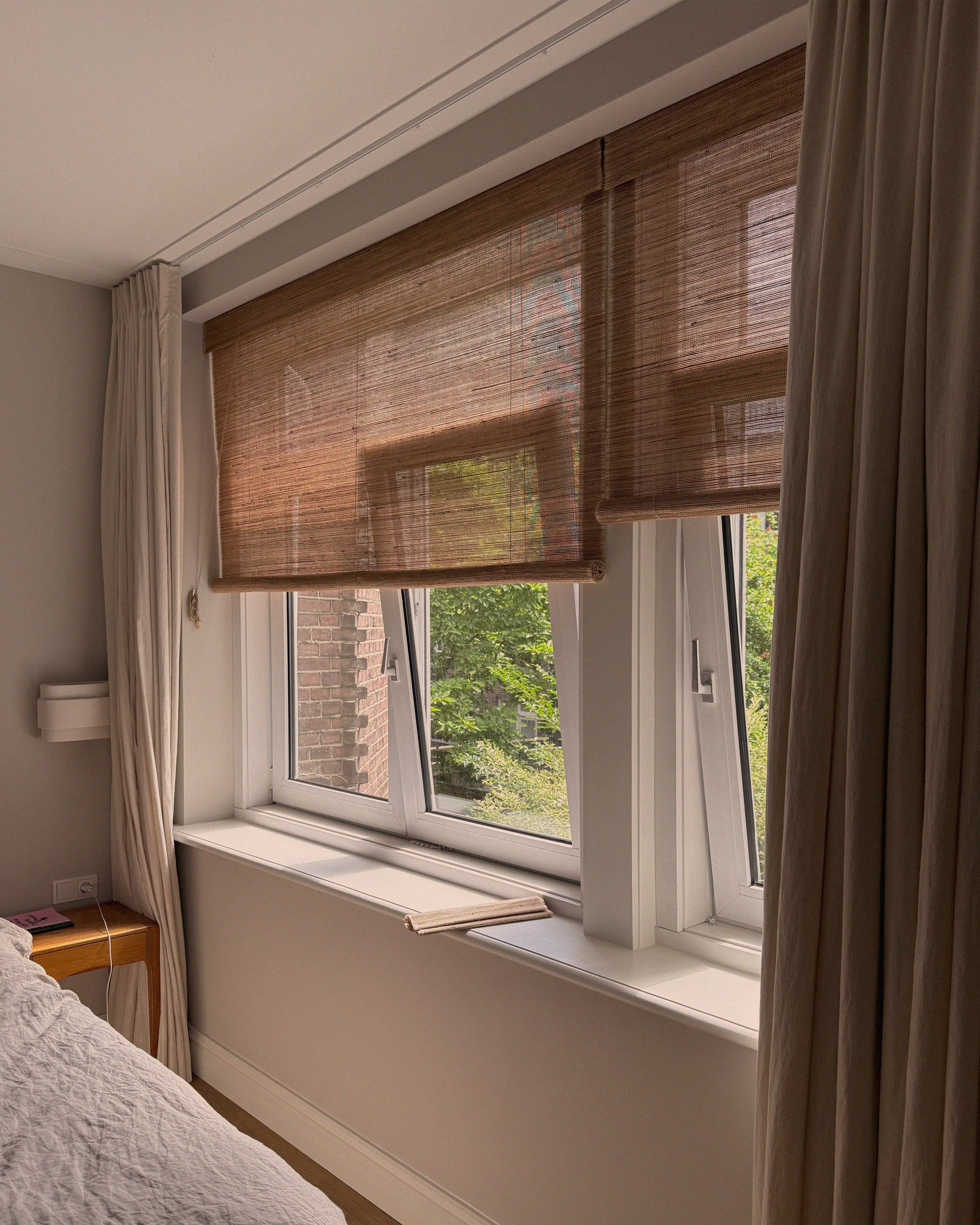 rolgordijnen en gevoerde linnen gordijnen in combinatie in een slaapkamer