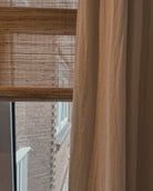 rolgordijnen en gevoerde linnen gordijnen in combinatie in een slaapkamer