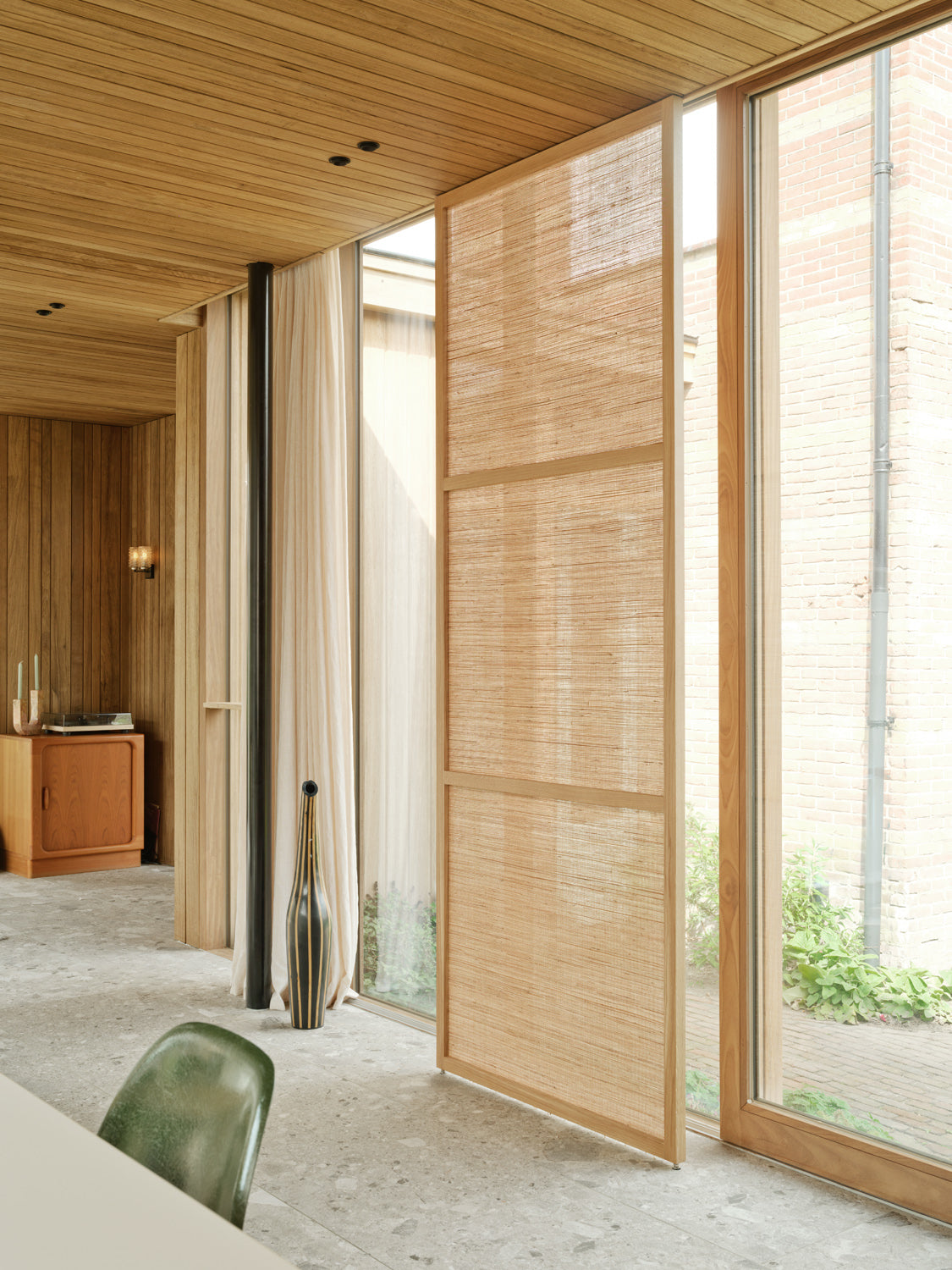Noble Weave roomdivider op maat van massief eikenhout met natuurlijk geweven paneel van hennep, jute, linnen en vlas. Zachte ruimteverdeling met gefilterd licht in een modern interieur.